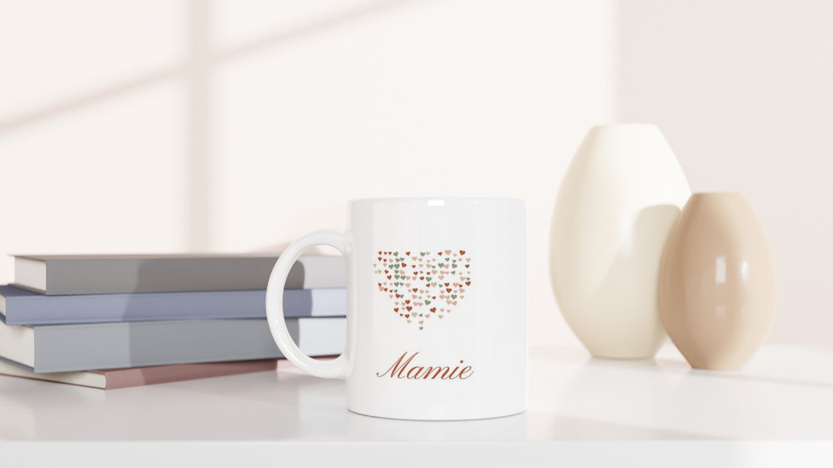 Mug Les petits cœurs de Mamie personnalisé posé près de livres et d’un vase